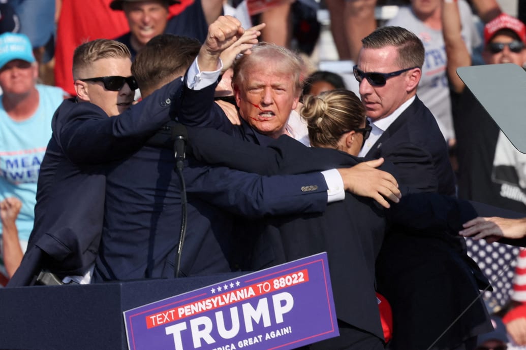 A bloodied Donald Trump raises his fist seconds after he was shot in the ear by a 20-year-old gunman.