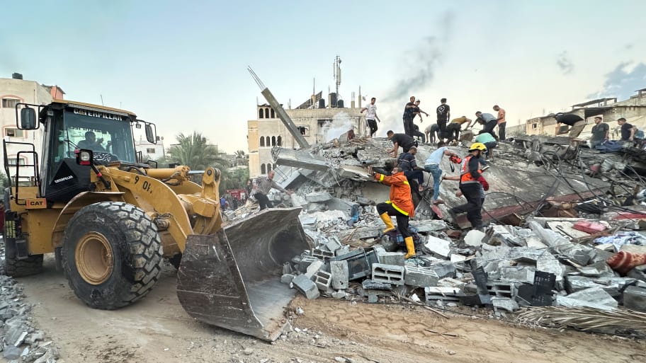 Palestinians work to remove the debris as they search for casualties under the rubble of a house destroyed by Israeli strikes, in the central Gaza Strip  October 15, 2023. 