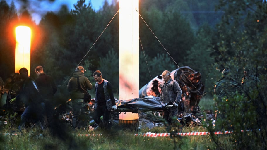 Emergency specialists carry a body bag near wreckage of the private jet linked to Wagner mercenary chief Yevgeny Prigozhin at the crash site in the Tver region, Russia, Aug. 24, 2023.