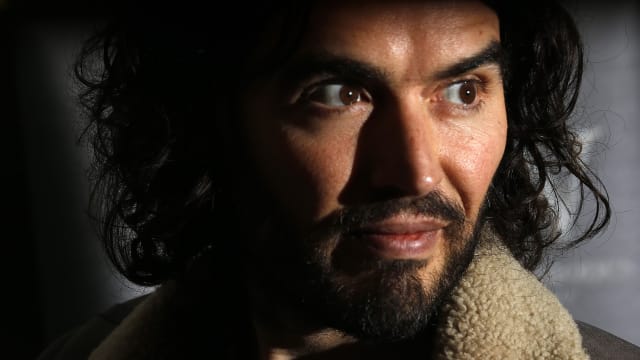 Comedian Russell Brand poses for photographers before signing copies of his new book entitled “Revolution” in central London, December 5, 2014.