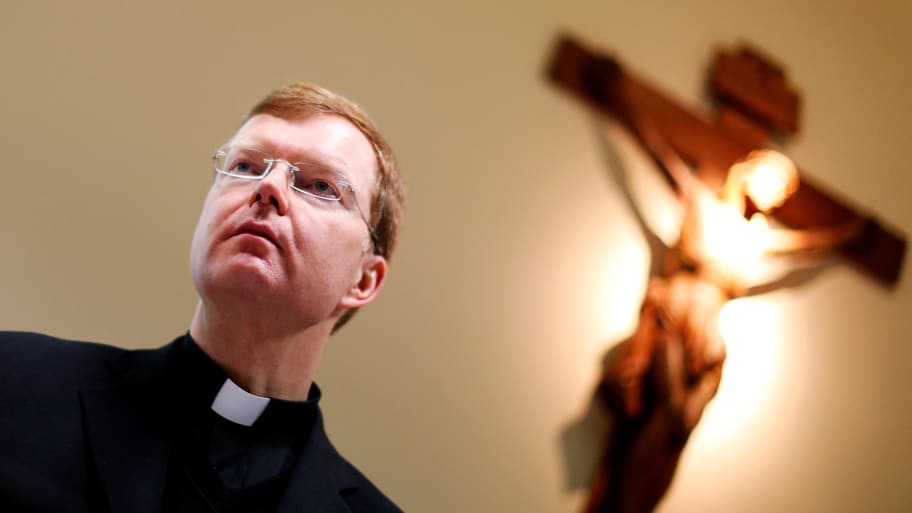 Hans Zollner appears before a blurred out crucifix