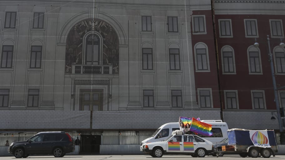 Gay rights activists wave flags from a car during a protest outside the Mayor's office in Moscow.