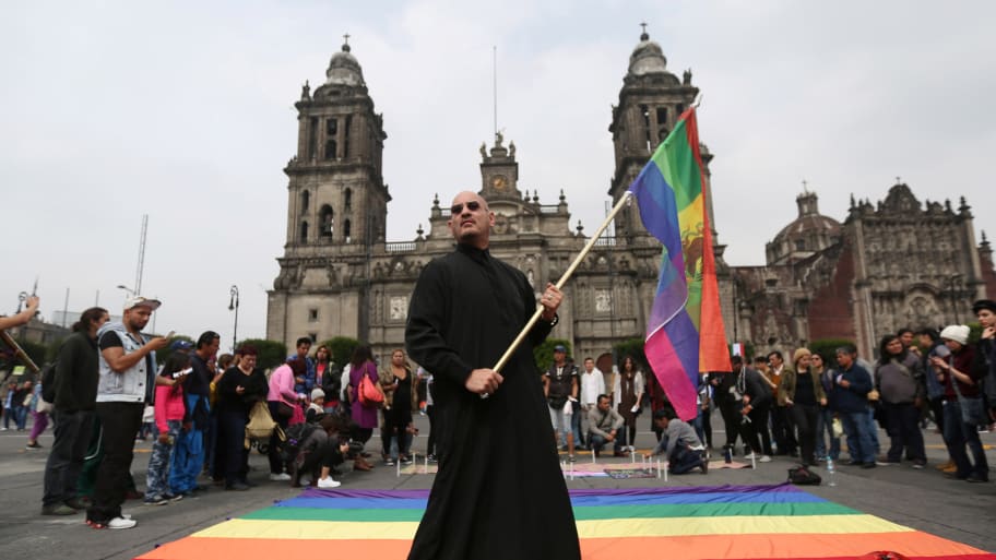 An activist holds a rainbow flag during a protest by the LGBT community against violence against transgenders outside Metropolitan Cathedral in Mexico City, Mexico, November 13, 2016.