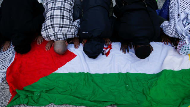 Pro-Palestinian supporters pray as they hold a protest near the Israeli Consulate