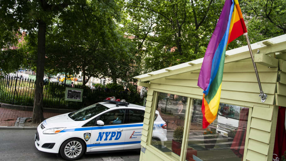 A NYPD car drives near a LGBTQ flag on June 1, 2021