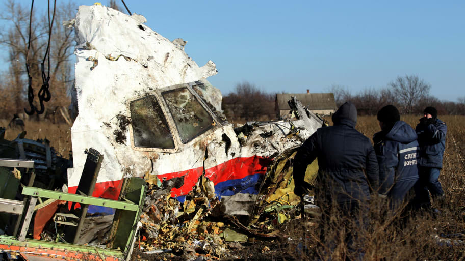 Local workers transport a piece of wreckage from Malaysia Airlines flight MH17 at the site of the plane crash near the village of Hrabove in Donetsk region, eastern Ukraine, Nov. 20, 2014. 