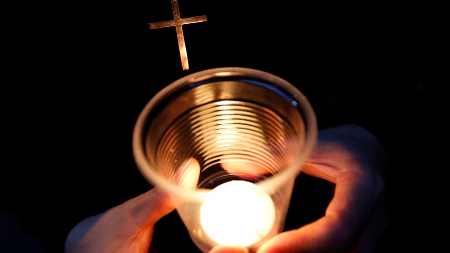 A Catholic nun holds a candle.