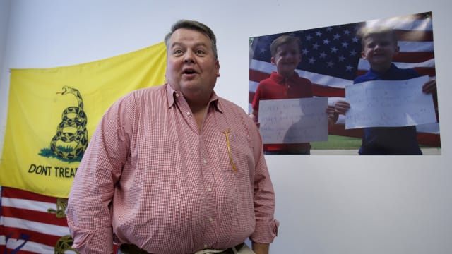 Bary Bennett speaks during a 2015 interview, with a yellow “Don’t Tread On Me” flag hanging in the background.