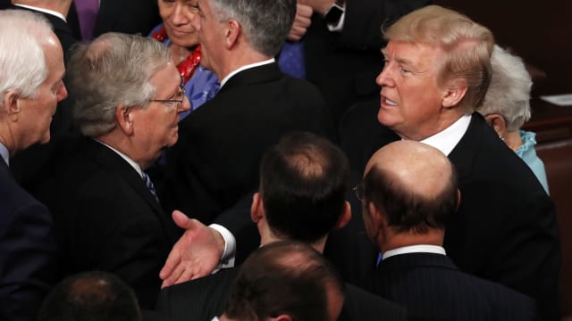 Donald Trump talks with U.S. Senate Majority Leader Mitch McConnell and Senate Majority Whip John Cornyn (L) after delivering his State of the Union address