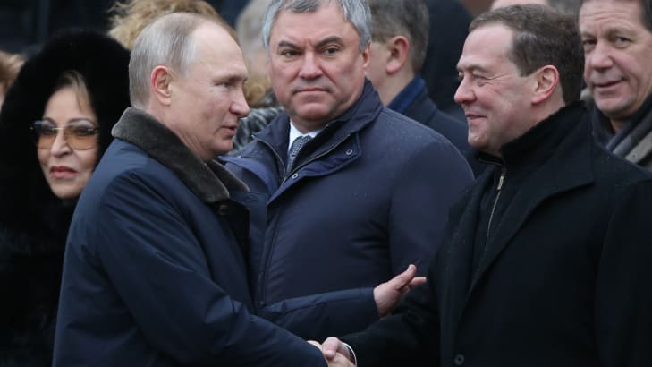 Russian President Vladimir Putin (L) greets Deputy Chairman of Security Council Dmitry Medvedev (R) as State Duma Speaker Vyacheslav Volodin (C) looks on.