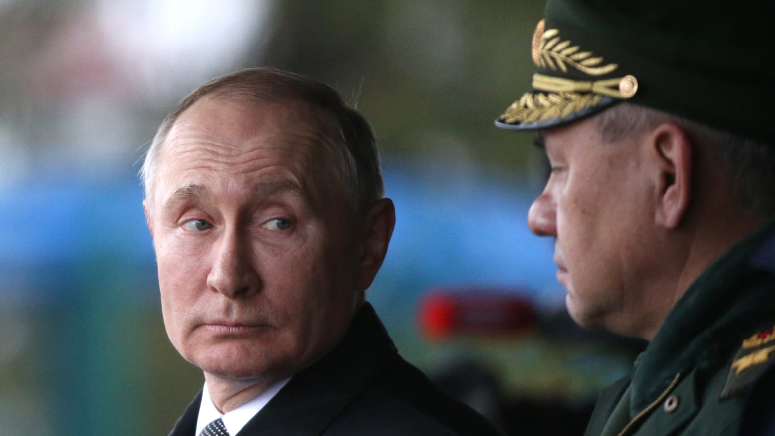 Russian President Vladimir Putin (L) looks at Defence Minister Sergei Shoigu (R)