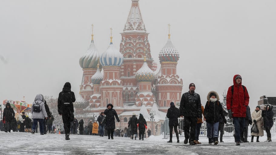 People walk in the Red Square with St. Basil’s Cathedral seen in the background, during heavy snowfall in Moscow, Russia, Dec. 14, 2022. 