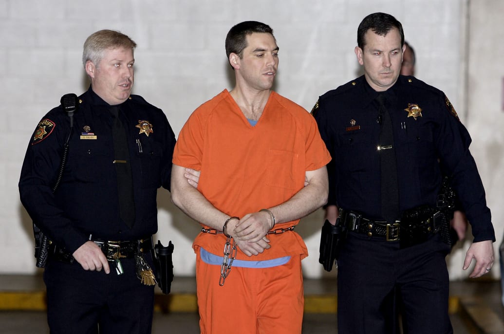Scott Peterson is escorted by deputies as he wears an orange prison jumpsuit.