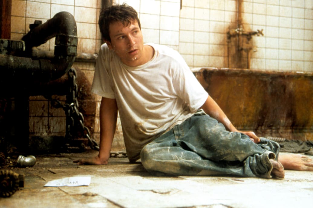 Leigh Whannell on the floor in a still from Saw.