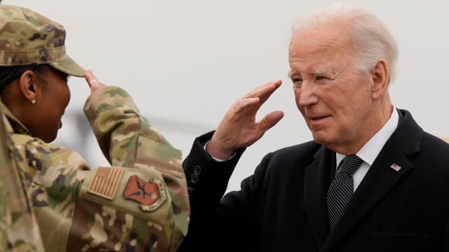 U.S. President Joe Biden salutes a military member