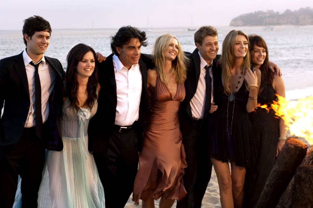 The cast of The OC hugging and hanging out on the beach in a still from 'The OC'