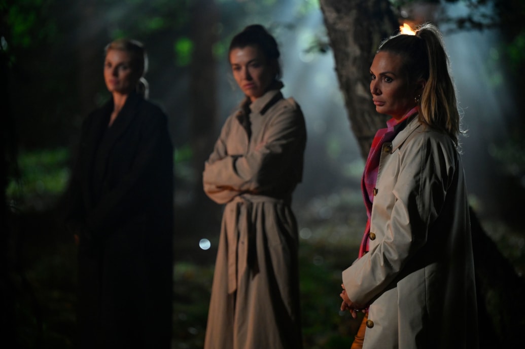 Kate Chastain stands with two other women looking at her in a still from ‘The Traitors’