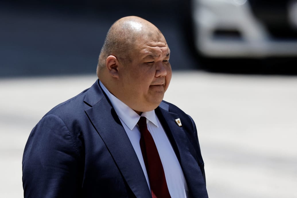 Steven Cheung walks on a tarmac