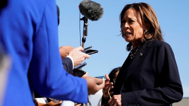 Kamala Harris speaks with reporters before boarding Air Force Two.