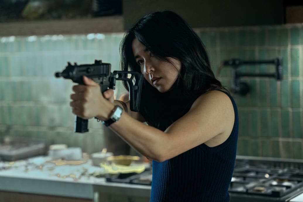 Maya Erskine holds up a rifle in a still from 'Mr and Mrs. Smith'