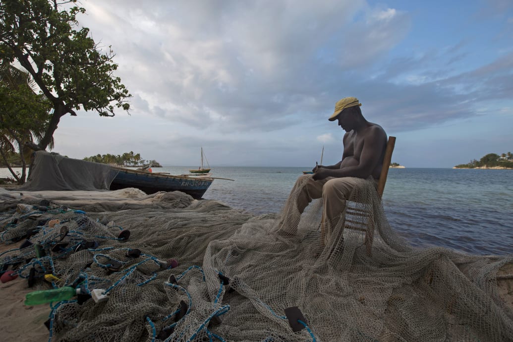 A picture of a fisherman mending his net in Ile-a-Vache