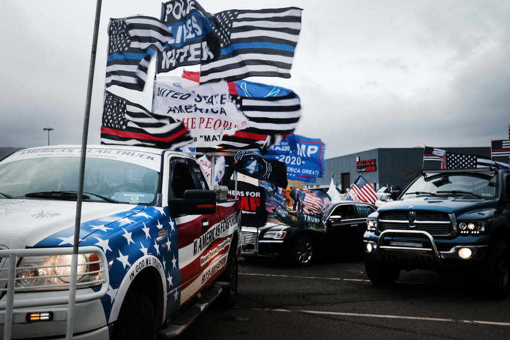 Cars and motorcycles with Trump flags waving.