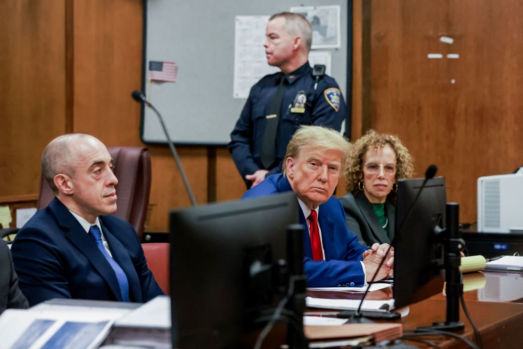 A photo of Donald Trump sitting in a courtroom.