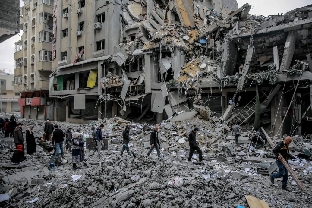A photo of Palestinians walking amid rubble in Gaza