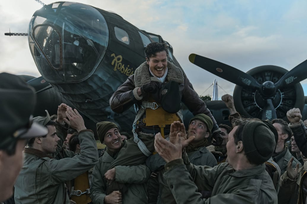 Nate Mann is carried by cheering soldiers in a still from 'Masters of the Air'