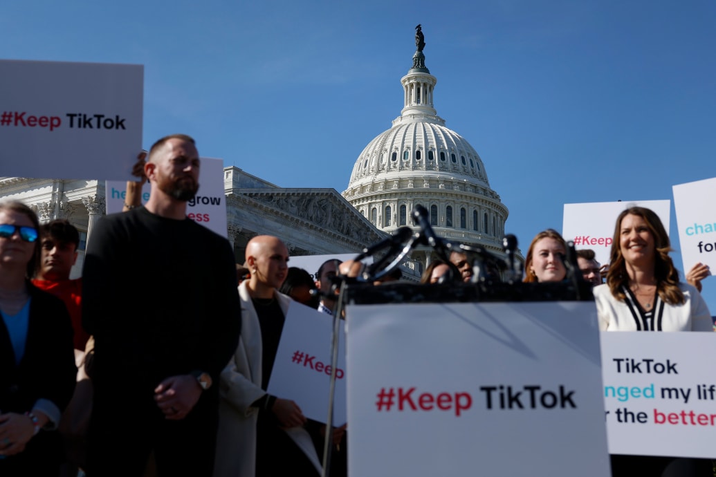 People hold signs in support of TikTok outside of the capitol
