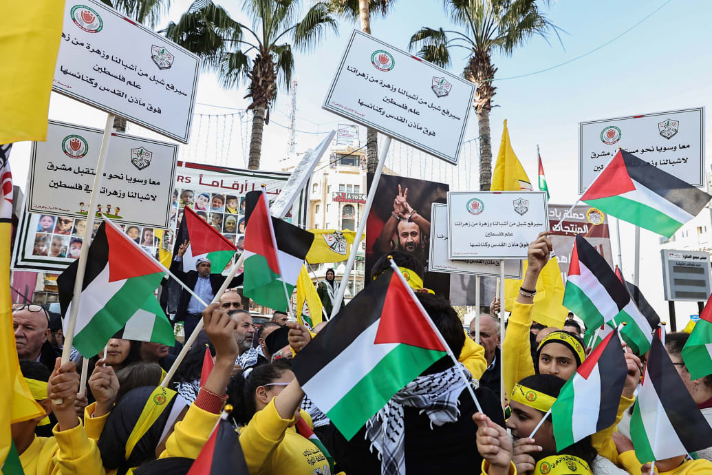 Fatah supporters lift flags and banners during a rally marking the 59th anniversary of the movement in Ramallah.