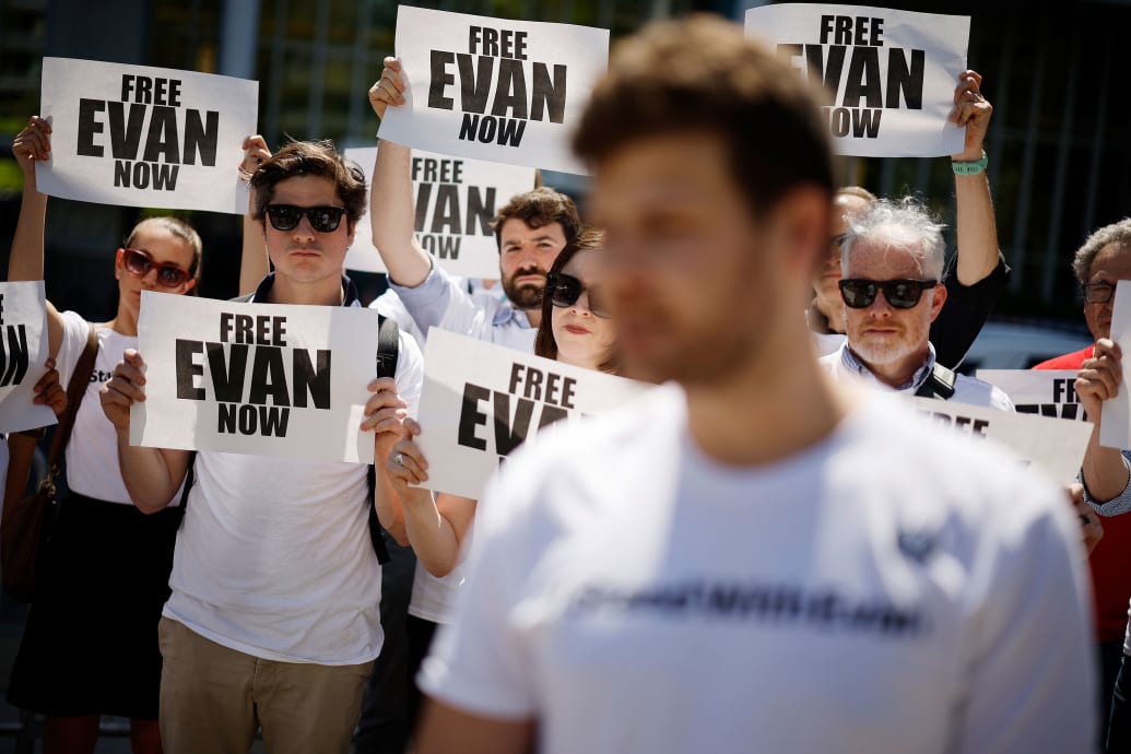 People hold signs that say Free Evan Now