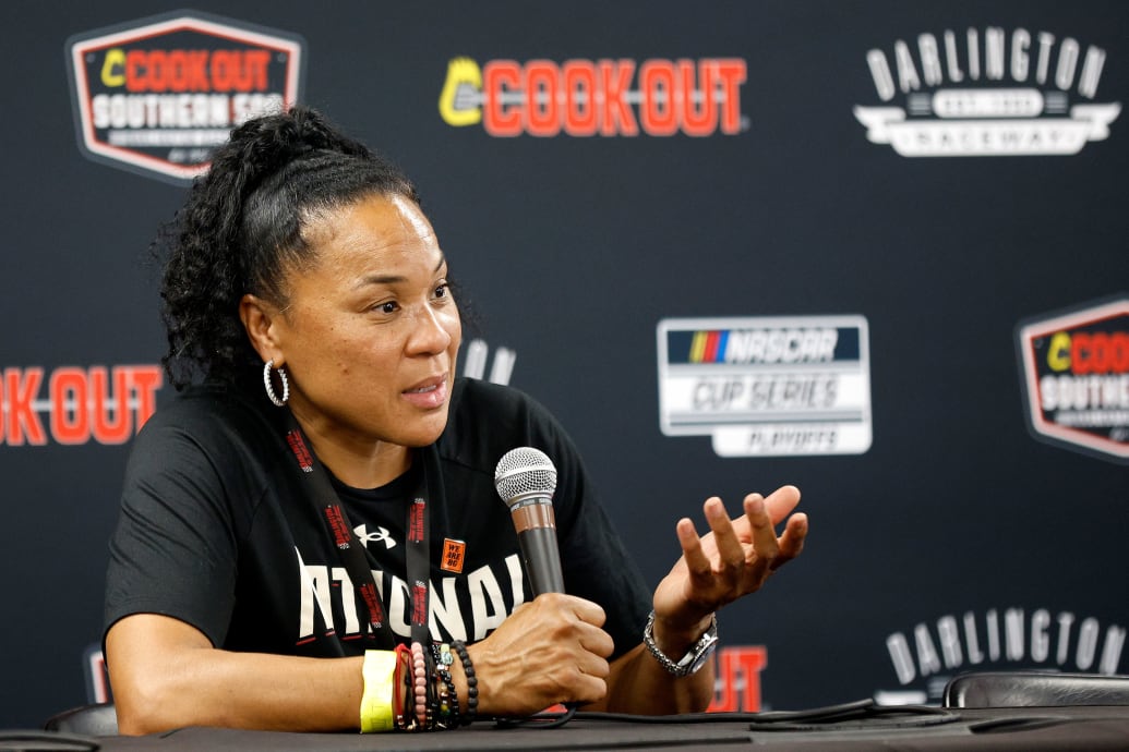 A photo of Dawn Staley talking at a press conference.