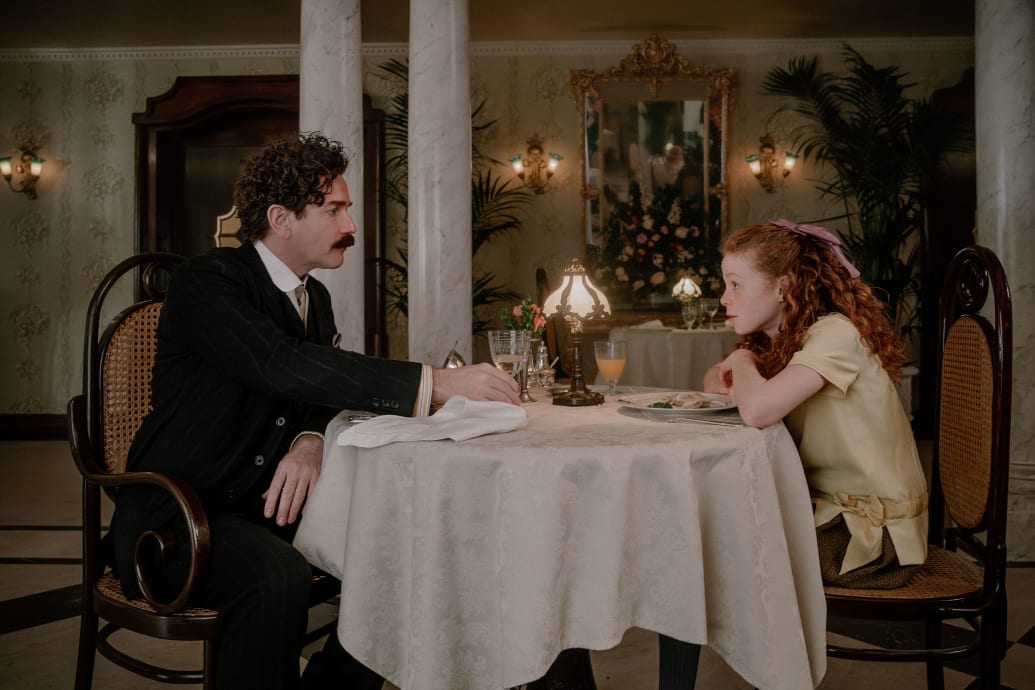 Ewan McGregor and Alexa Goodall sit at a table in a still from Gentleman in Moscow