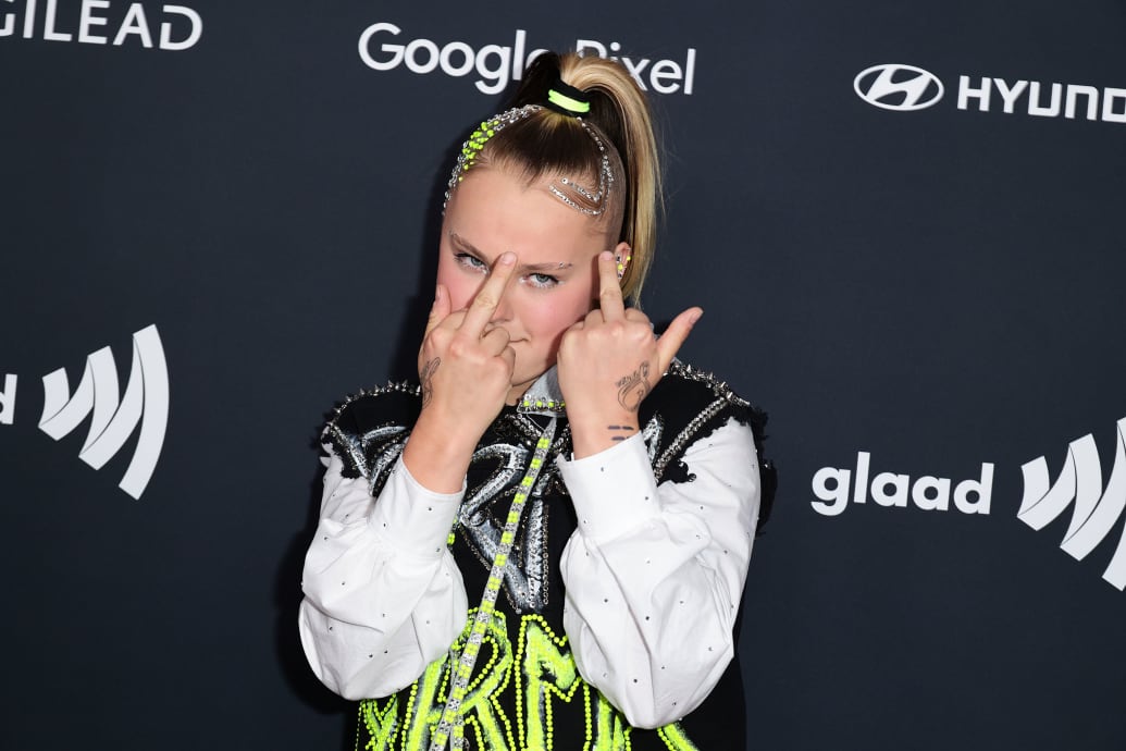 Jojo Siwa flips her middle fingers at a step and repeat.