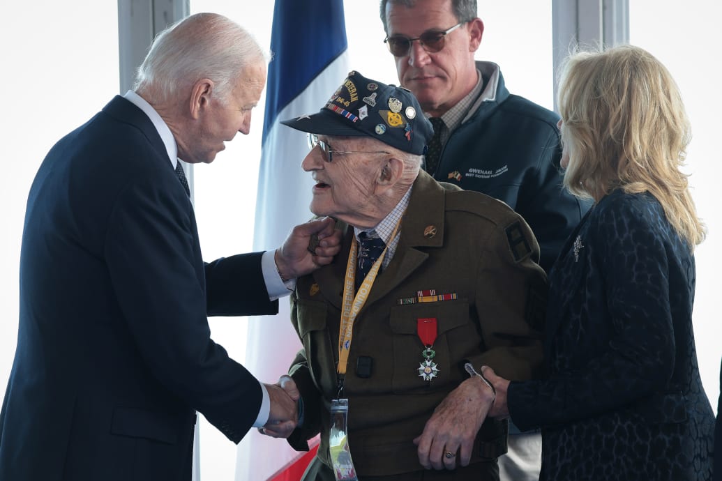 Joe Biden greets a WWII veteran at a ceremony in Normandy. 