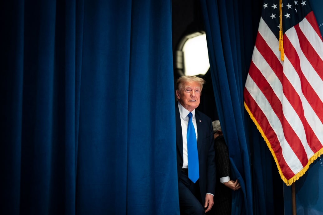 Donald Trump peeks out behind a curtain