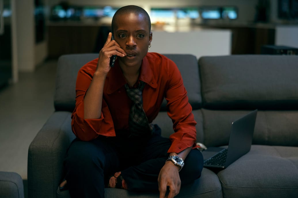 ’Nia Miller on a couch on the phone  in a still from ‘The Fall of the House of Usher’