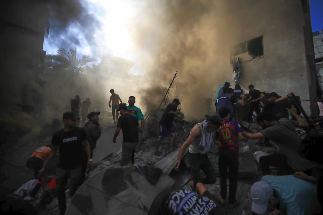  A group of civilians search through rubble after an Israeli attack in Gaza