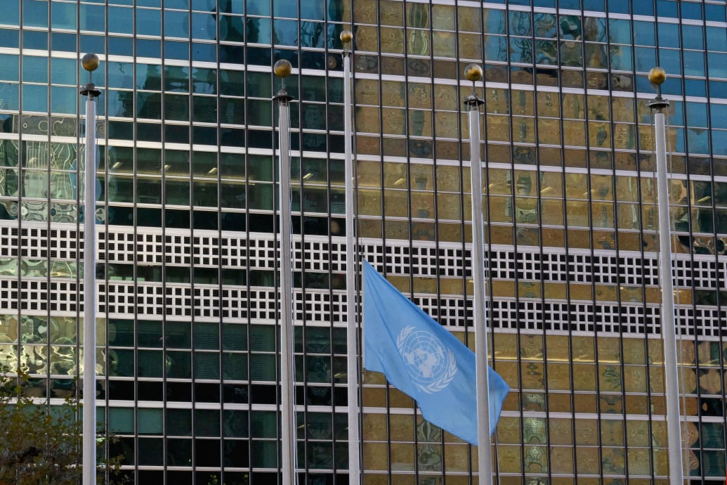 A photo shows the UN headquarters with a UN flag flying at half mast. 