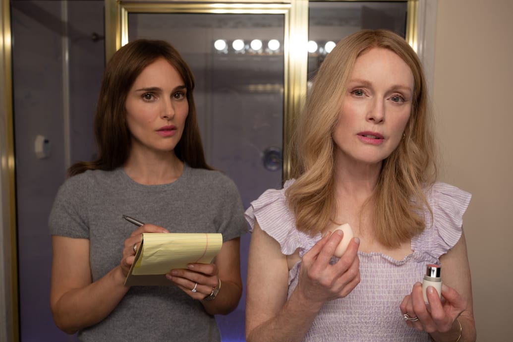 Natalie Portman holds a reporter notebook next to Julianne Moore in a still from 'May December'