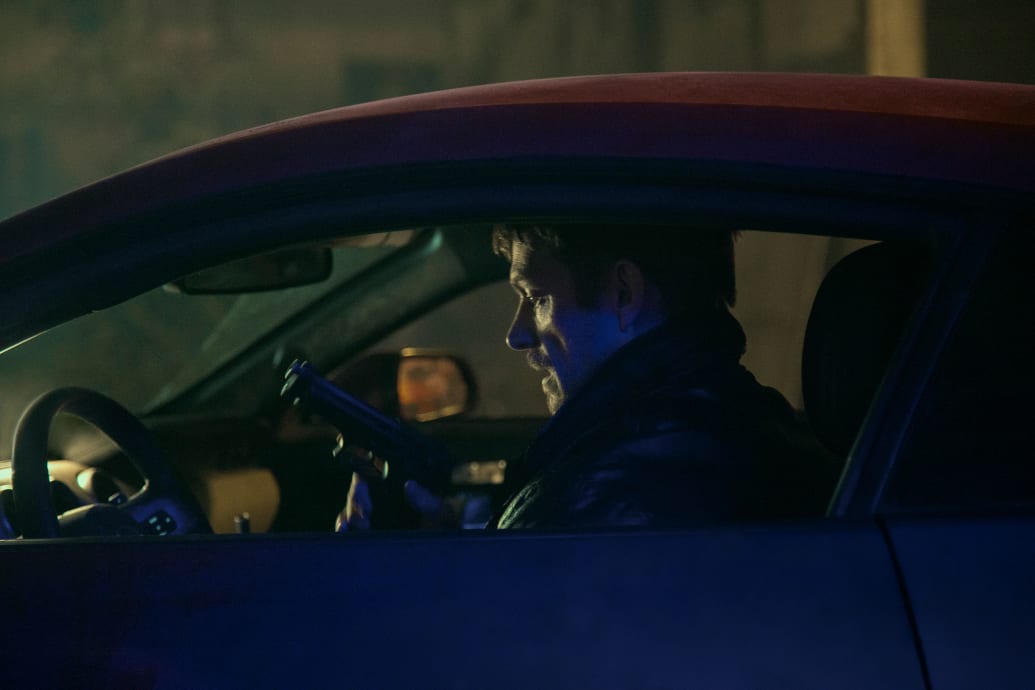 Joel Kinnaman sitting in a car in a still from 'Silent Night'