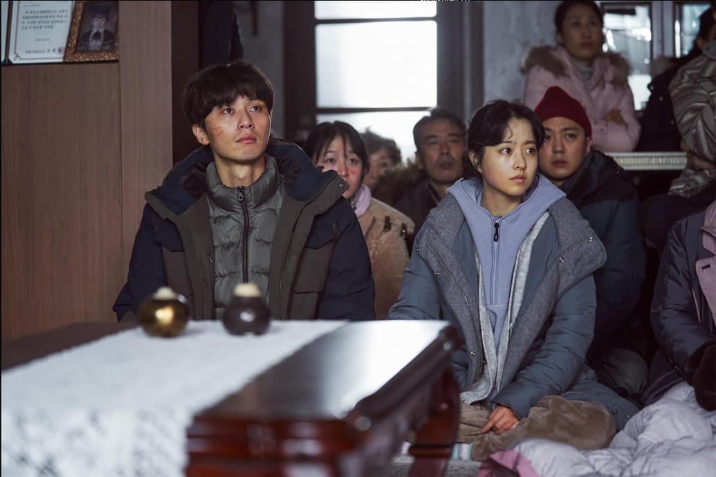Park Seo-joon and Park Bo-young sit next to each other in a still from 'Concrete Utopia'