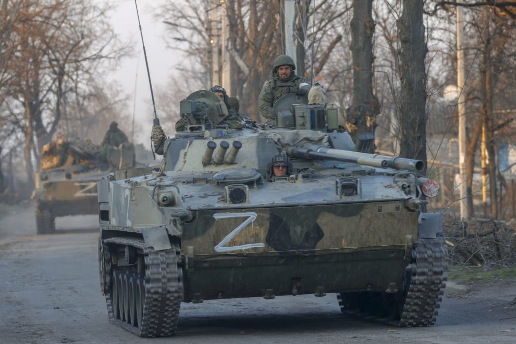 A picture of a tank with Russian soldiers riding through Volnovaha. 