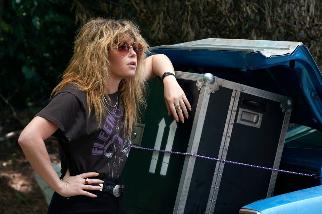Natasha Lyonne leans against boxes in a still from ‘Poker Face’