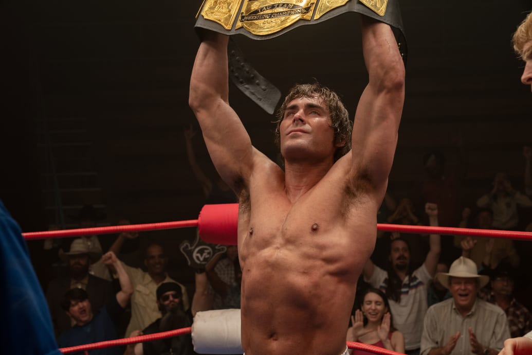 Zac Efron holds up a championship belt in a still from ‘The Iron Claw’