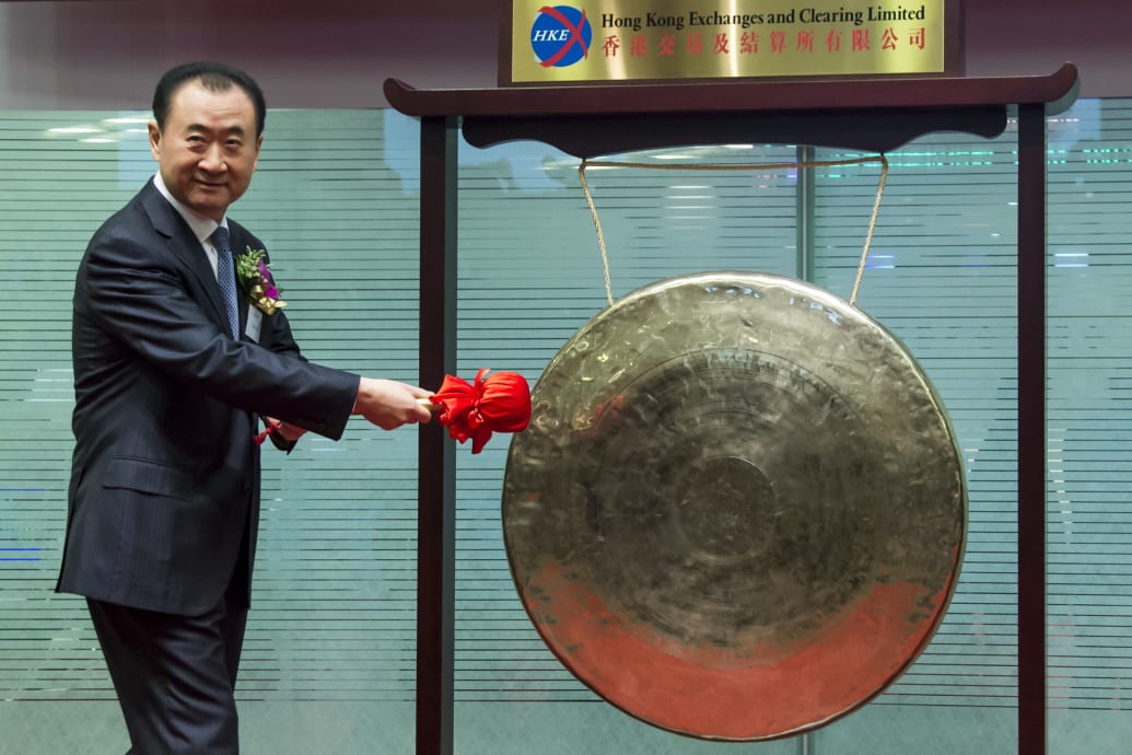 Wang Jianlin strikes a gong during the debut of Wanda at the Hong Kong Stock Exchange in 2014.