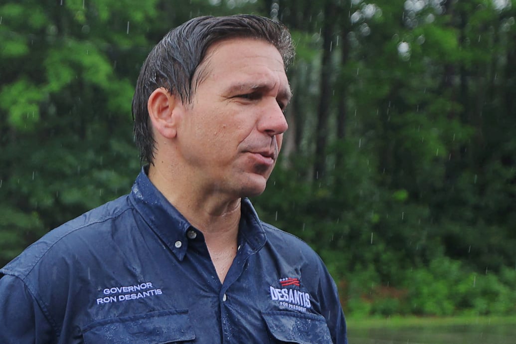 Florida Governor Ron DeSantis talks to reporters after walking in the Fourth of July Parade in the rain in Merrimack, New Hampshire.