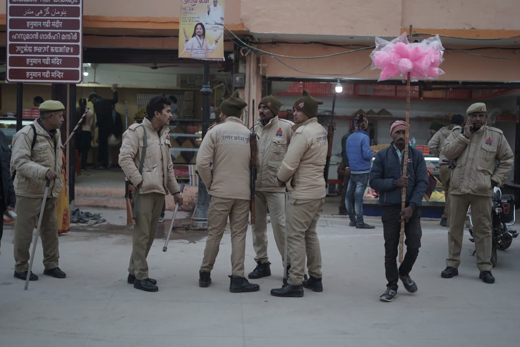 Uttar Pradesh police personnel stand guard along the path leading to Ram Mandir, announcing instructions for visitors to deposit their mobile phones and bags before entering the temple premises.