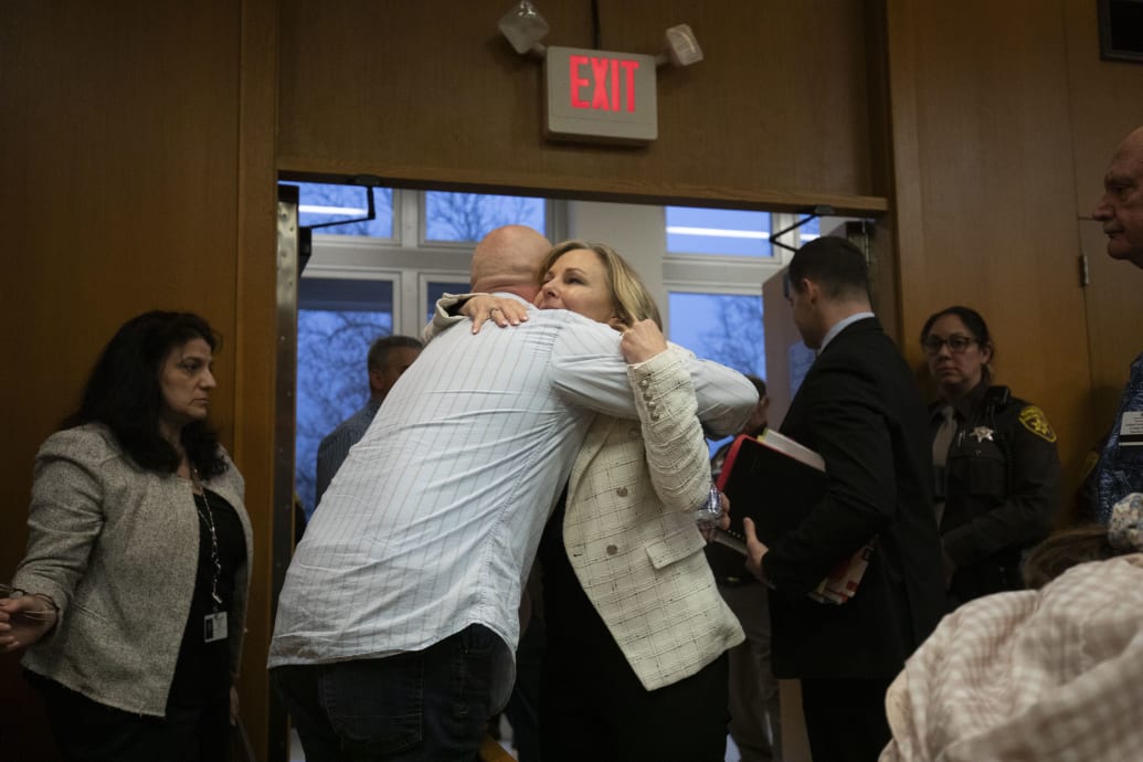 Oakland County Prosecutor Karen McDonald hugs family members of the students who were killed by Oxford High School shooter Ethan Crumbley after Crumbley's father James Crumbley was found guilty 